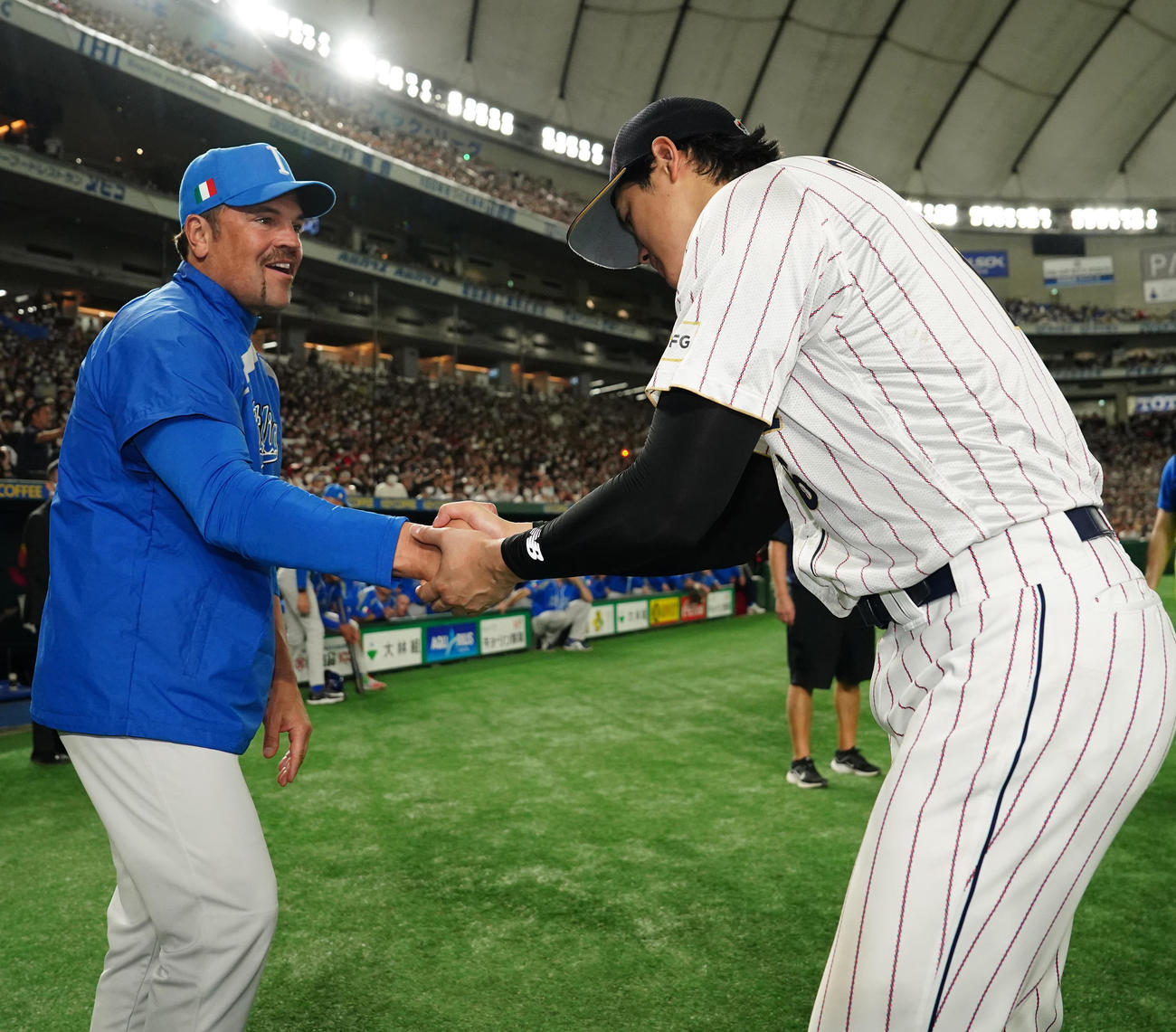 日本対イタリア　試合後、イタリア代表ピアザ監督（左）と握手を交わす大谷（撮影・江口和貴）
