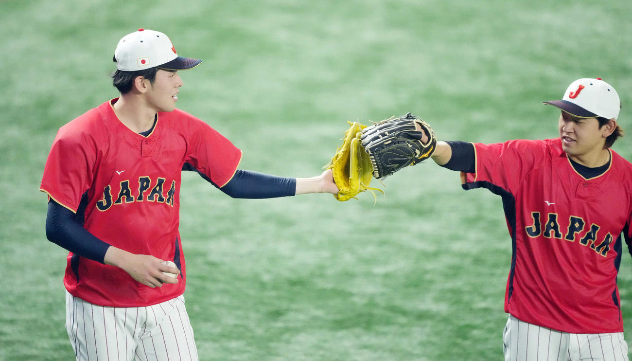 日本対イタリア　試合前練習のキャッチボールを終え、タッチを交わす佐々木（左）と宮城（撮影・鈴木みどり）