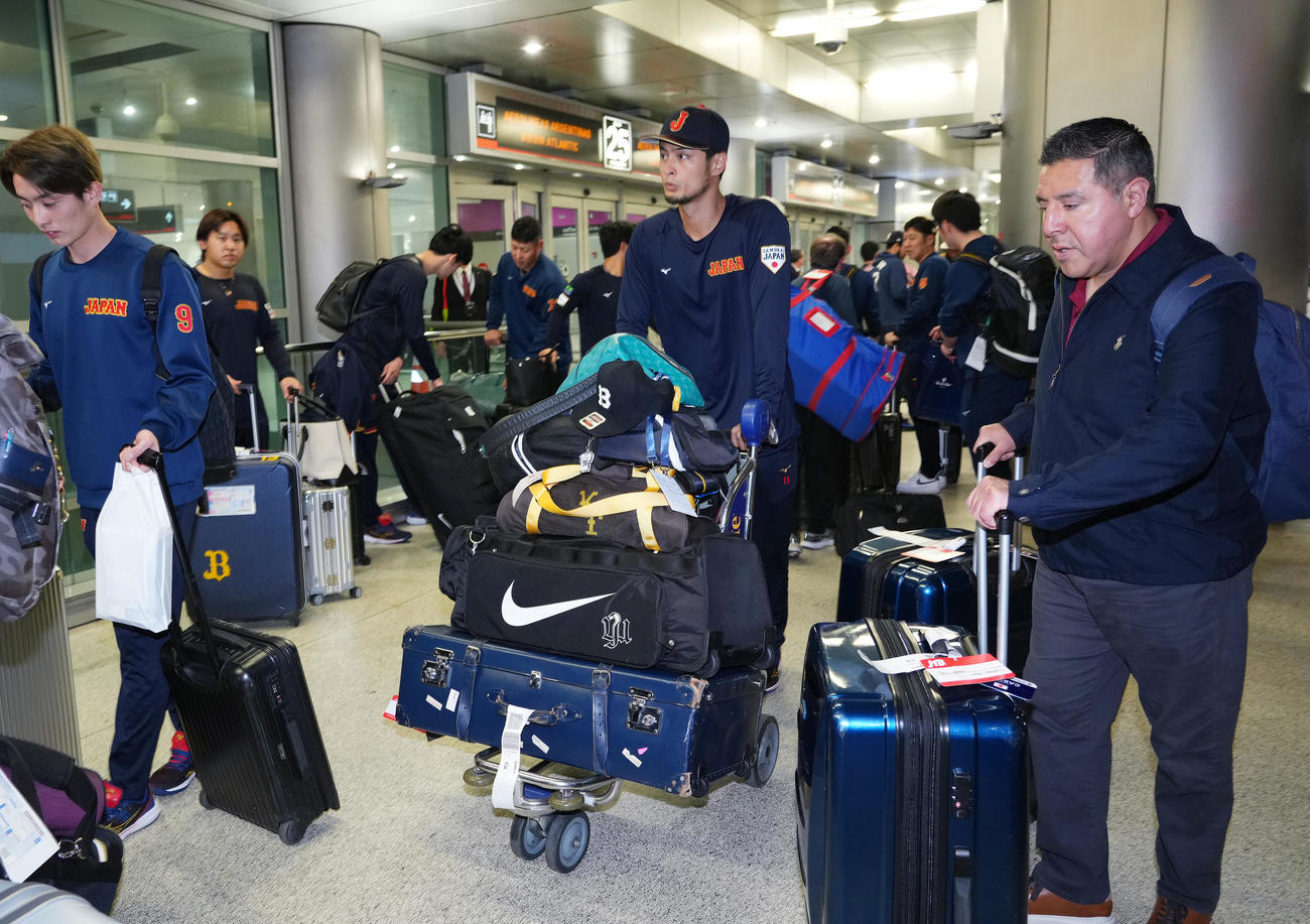 準決勝・決勝が行われる米国マイアミに到着し、荷物を運ぶダルビッシュ（中央）（撮影・菅敏）