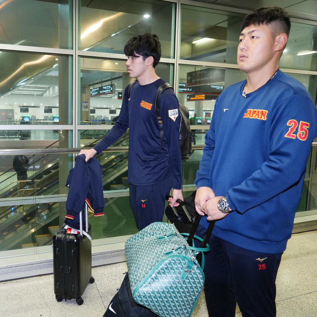 準決勝・決勝が行われる米国マイアミに到着し、荷物を運ぶ佐々木と岡本（右）（撮影・菅敏）