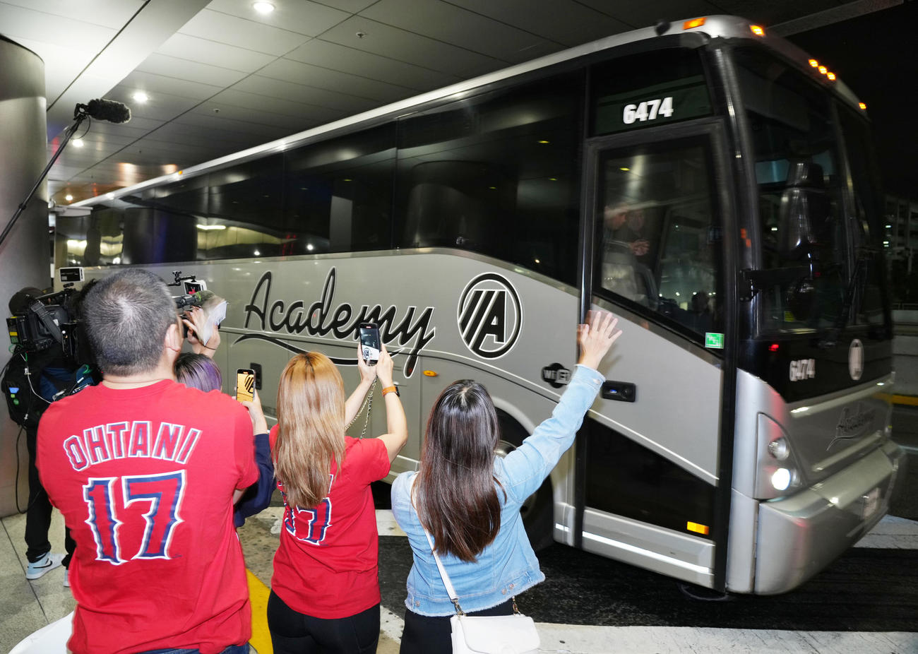 空港から移動する日本の選手たちを乗せたバスに手を振るファン（撮影・菅敏）