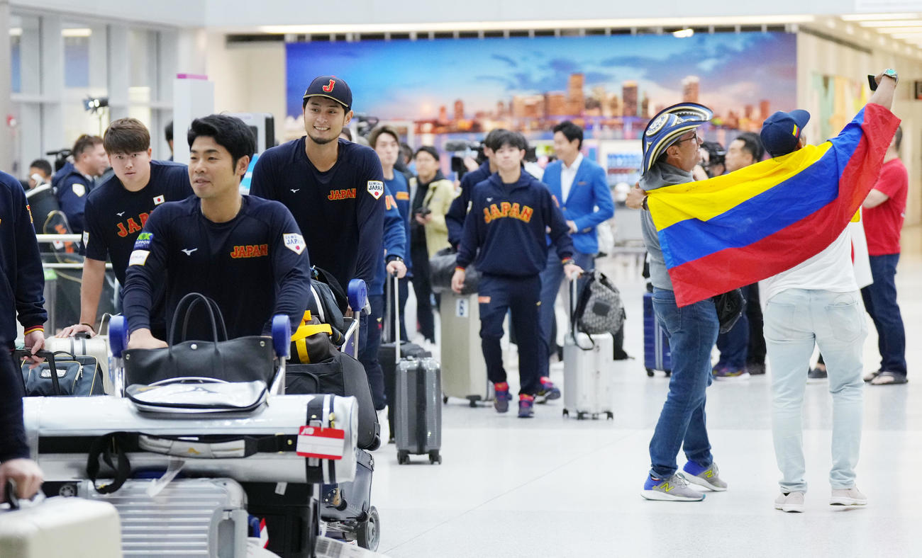 準決勝・決勝が行われる米国マイアミに到着し、盛り上がるベネズエラのファンを横目に荷物を運ぶ、左から村上、近藤、ダルビッシュ（撮影・菅敏）