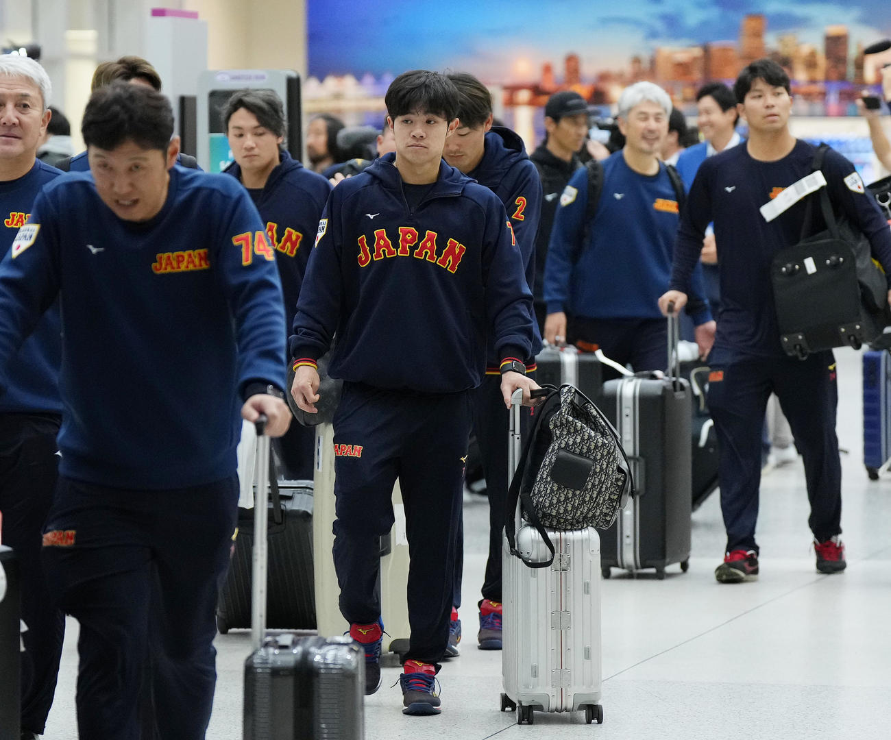 準決勝・決勝が行われる米国マイアミに到着し、荷物を運ぶ中野（中央）（撮影・菅敏）