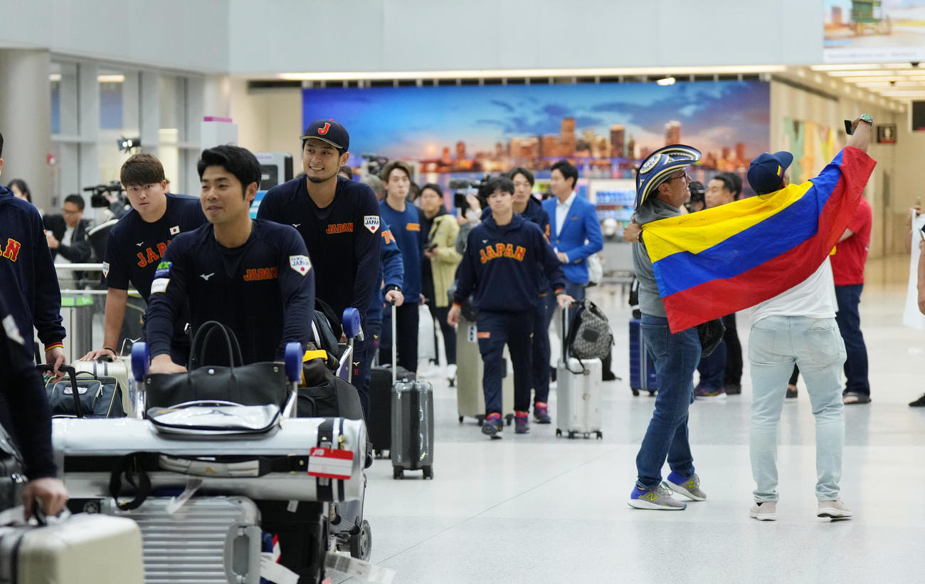 準決勝・決勝が行われる米国マイアミに到着し、盛り上がるベネズエラのファンを横目に荷物を運ぶ、左から村上、近藤、ダルビッシュ（撮影・菅敏）