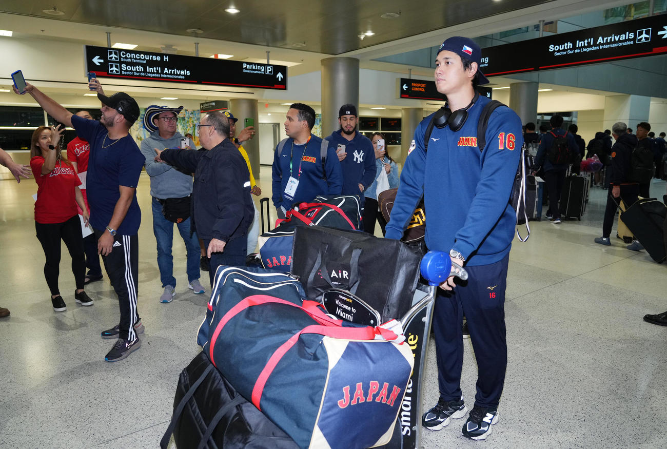 準決勝・決勝が行われる米国マイアミに到着し、ファンに写真を撮られながら移動する大谷（手前）（撮影・菅敏）