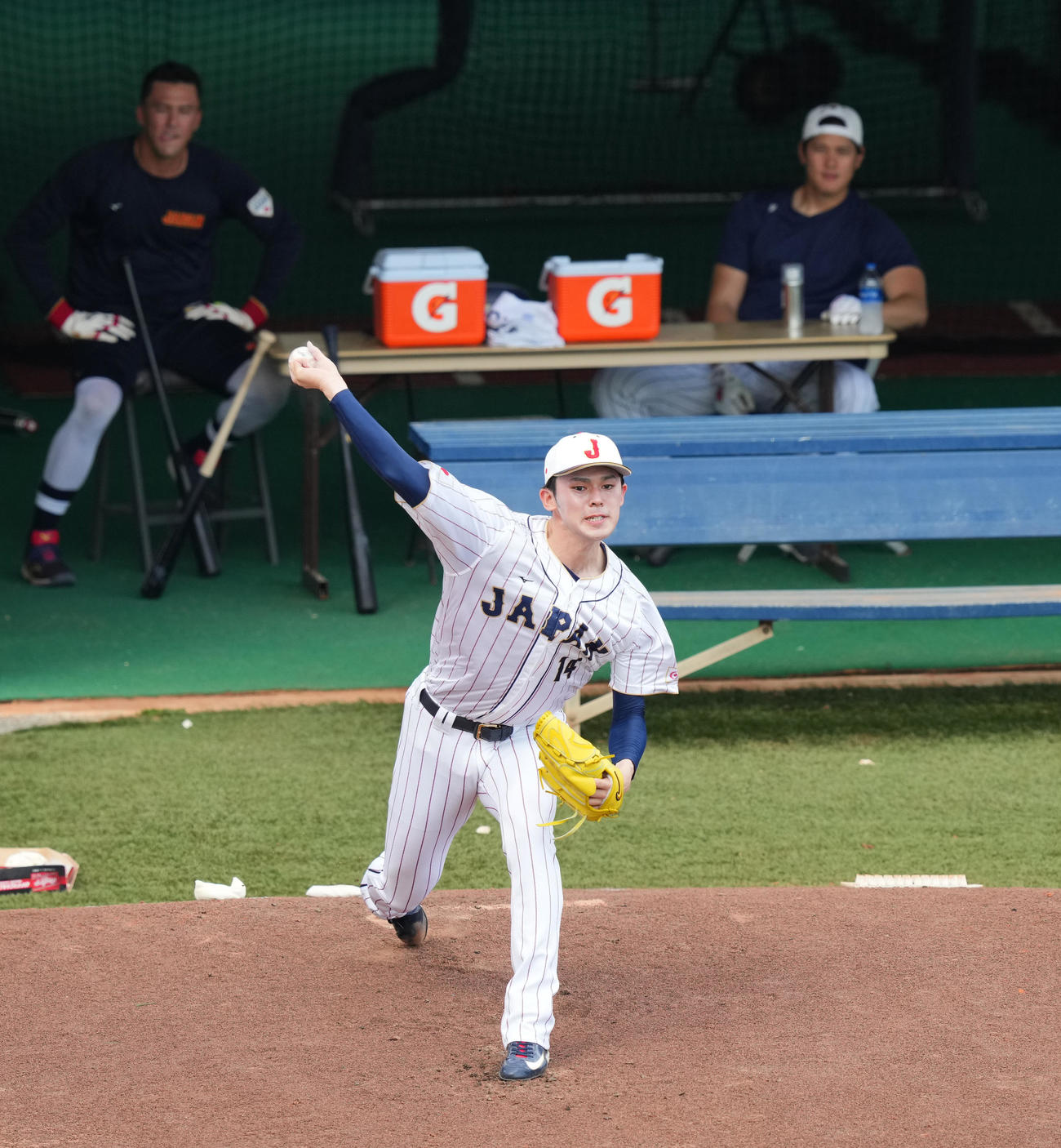 ブルペンで大谷（右奥）、ヌートバー（左奥）の視線を受けながら投球練習をする佐々木（撮影・菅敏）
