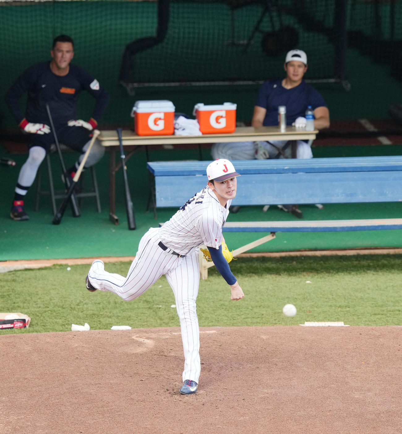 ブルペンで大谷（右奥）、ヌートバー（左奥）の視線を受けながら投球練習をする佐々木（撮影・菅敏）
