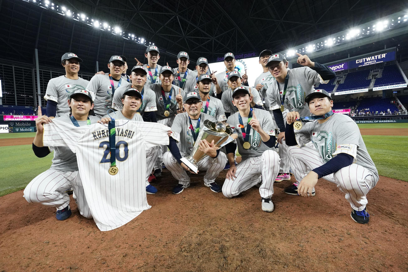 途中離脱した栗林のユニフォームとともに記念撮影に収まる侍ジャパンの選手たち（AP）