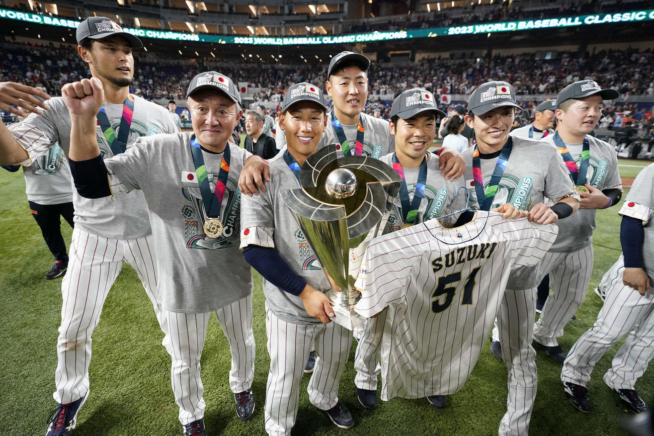 鈴木のユニホームを手に記念撮影する吉田（中央）ら日本の選手たち（AP）
