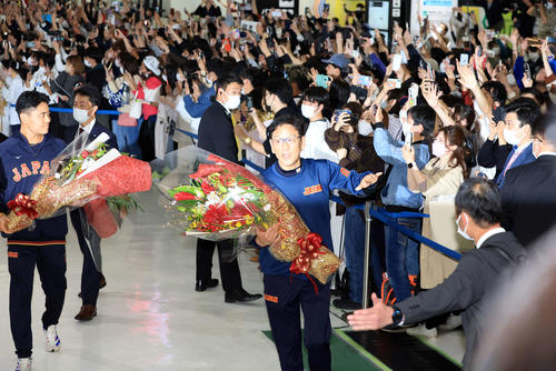 大勢のファンが待つ中、帰国した日本代表の栗山監督（中央）は手を振る。左は中村（撮影・浅見桂子）