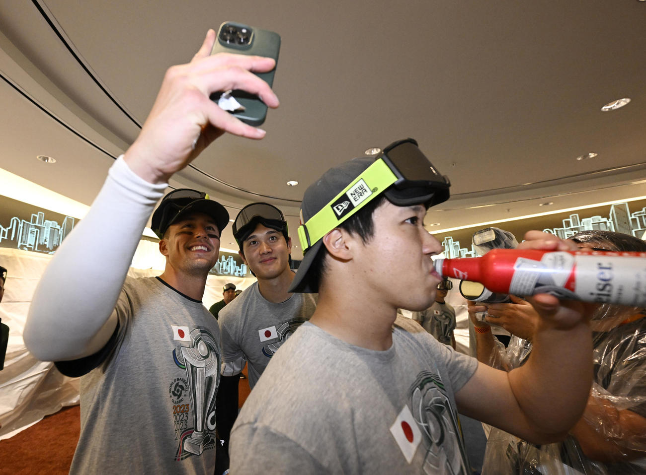 試合後のビールかけの前に写真に納まるヌートバー（左）、大谷（中央）。手前はビールを飲む山田（2023年3月21日）