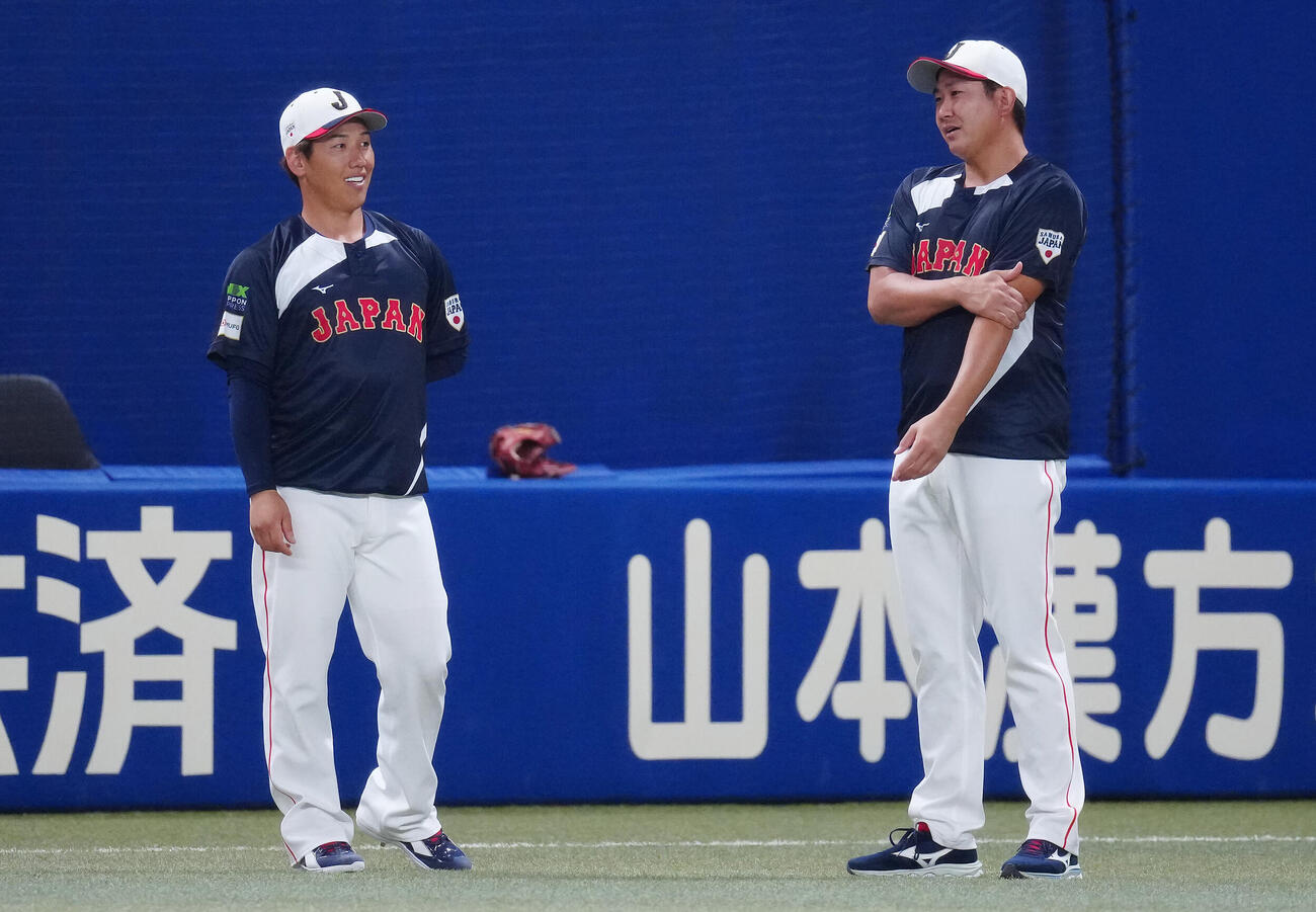 練習中言葉を交わす菅野（右）と吉田（撮影・垰建太）