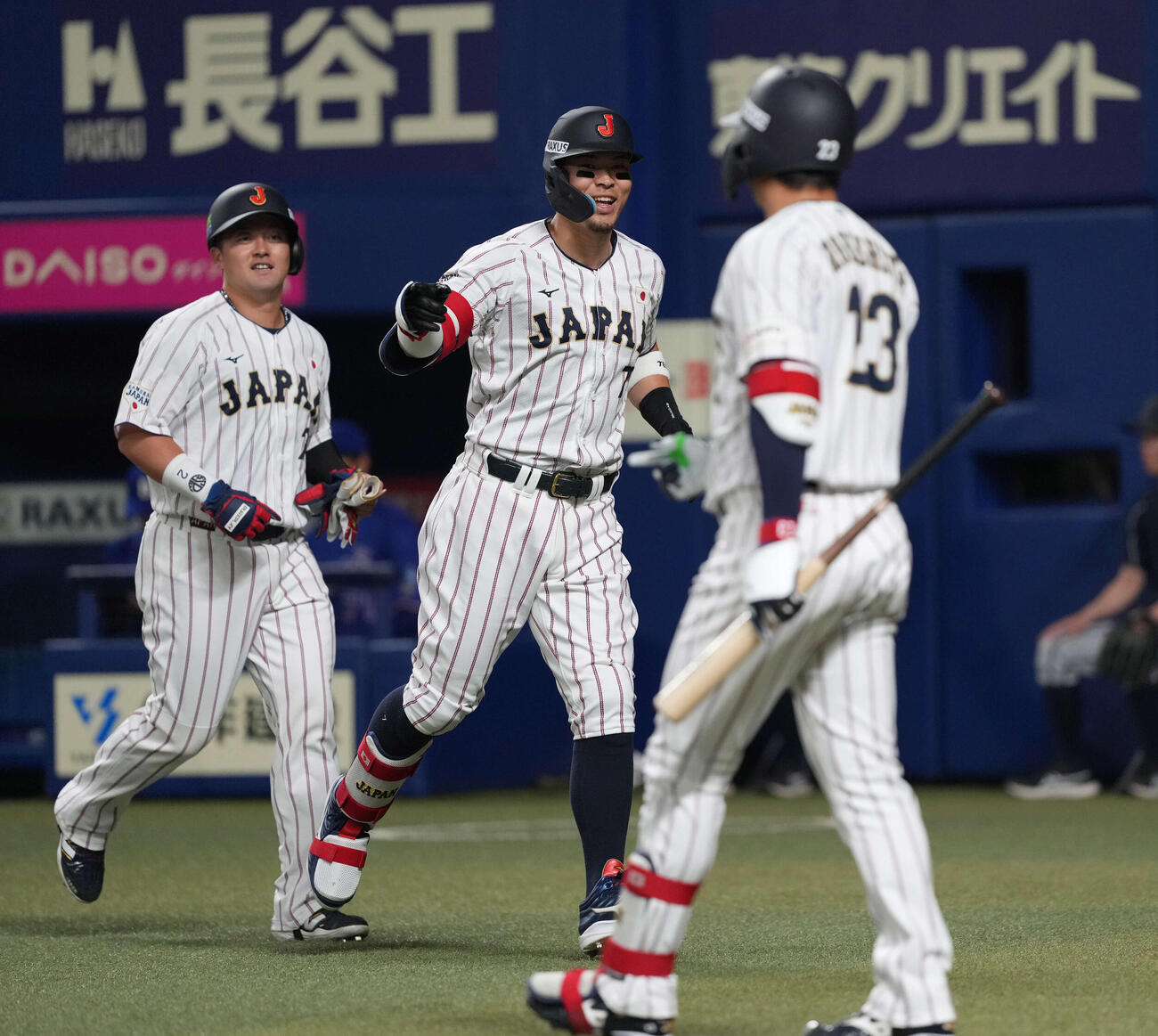 日本対中日　1回裏日本1死一、二塁、3点本塁打を放ち笑顔で生還する佐藤（中央）（撮影・井上学）