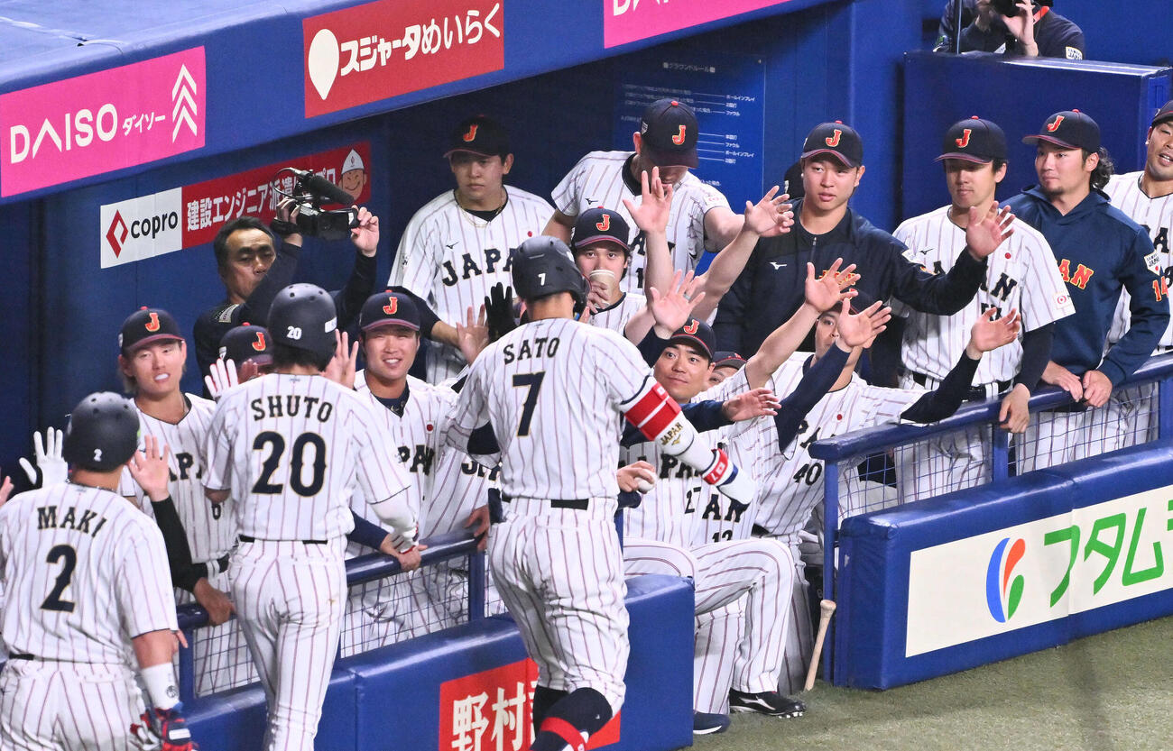 日本対中日　1回裏日本1死一、二塁、先制3点本塁打を放った佐藤（手前）を迎える大谷（後方中央）ら（撮影・滝沢徹郎）
