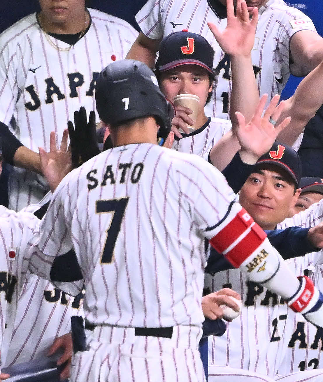 日本対中日　1回裏日本1死一、二塁、先制3点本塁打を放った佐藤（手前）を迎える大谷（後方中央）（撮影・滝沢徹郎）