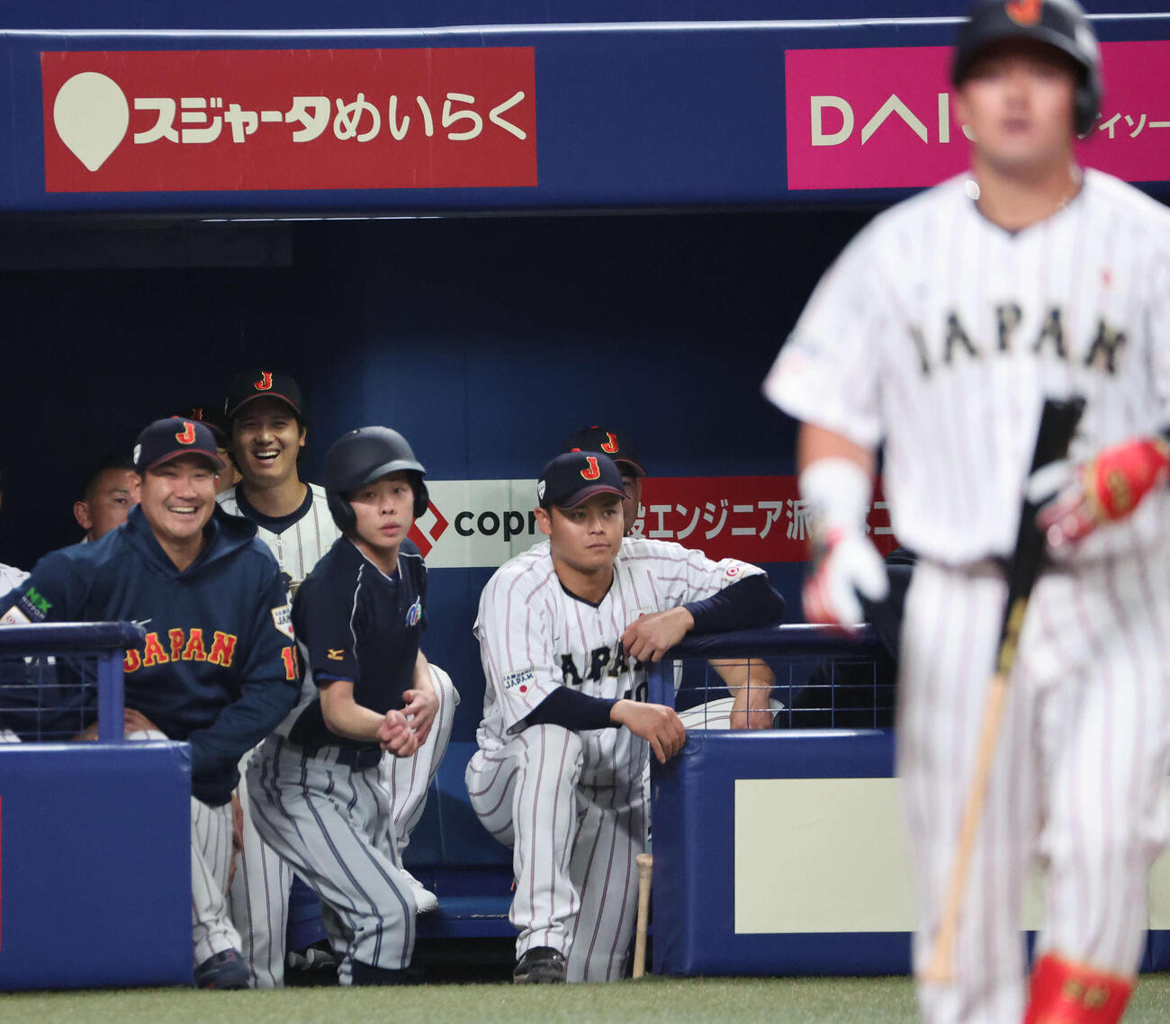 日本対中日　1回裏日本1死一塁、牧が死球を受けベンチで笑う大谷と菅野（撮影・西尾就之）