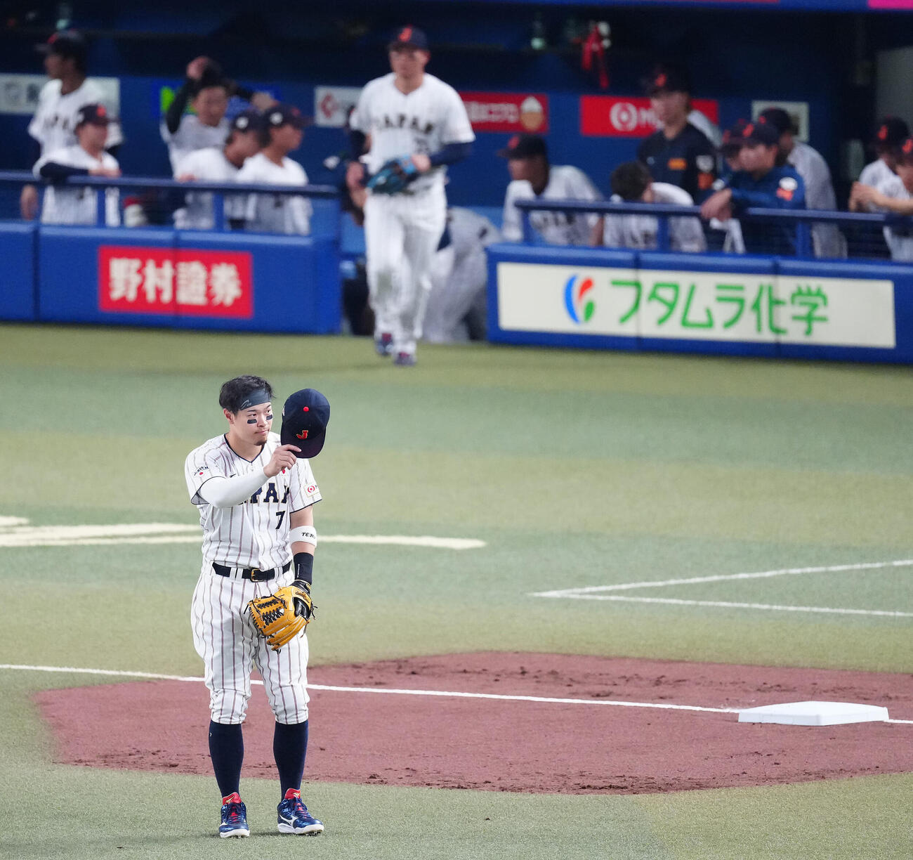 日本対中日　1回裏の攻撃を終え先制本塁打を放った佐藤は三塁の守備位置に就きファンの声援に応える（撮影・垰建太）