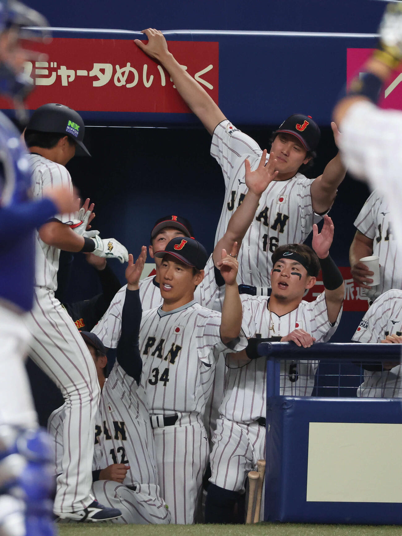 日本対中日　2回裏日本2死、サポートメンバーの佐々木が本塁打を放ち、ベンチ後方から伸び上がって迎える大谷（撮影・西尾就之）
