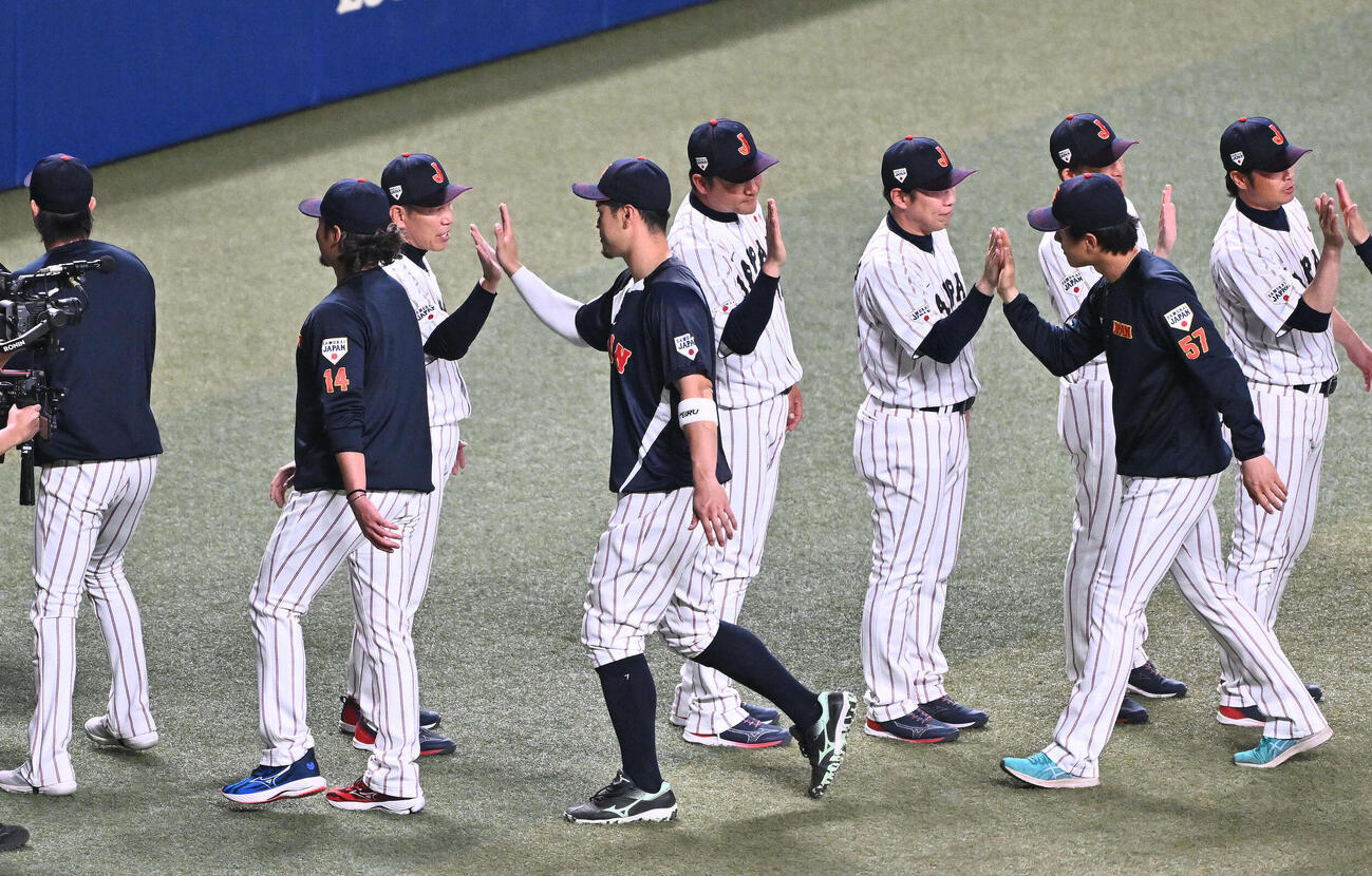日本対中日　試合後、侍ジャパン井端監督（左から3人目）は佐藤とタッチを交わす（撮影・滝沢徹郎）