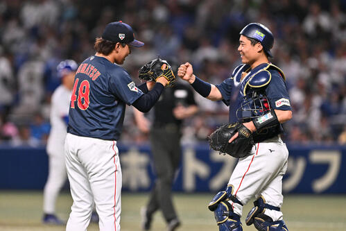 中日対日本 試合を締めた日本5番手の東松(左)は中村とタッチを交わす(撮影・滝沢徹郎)