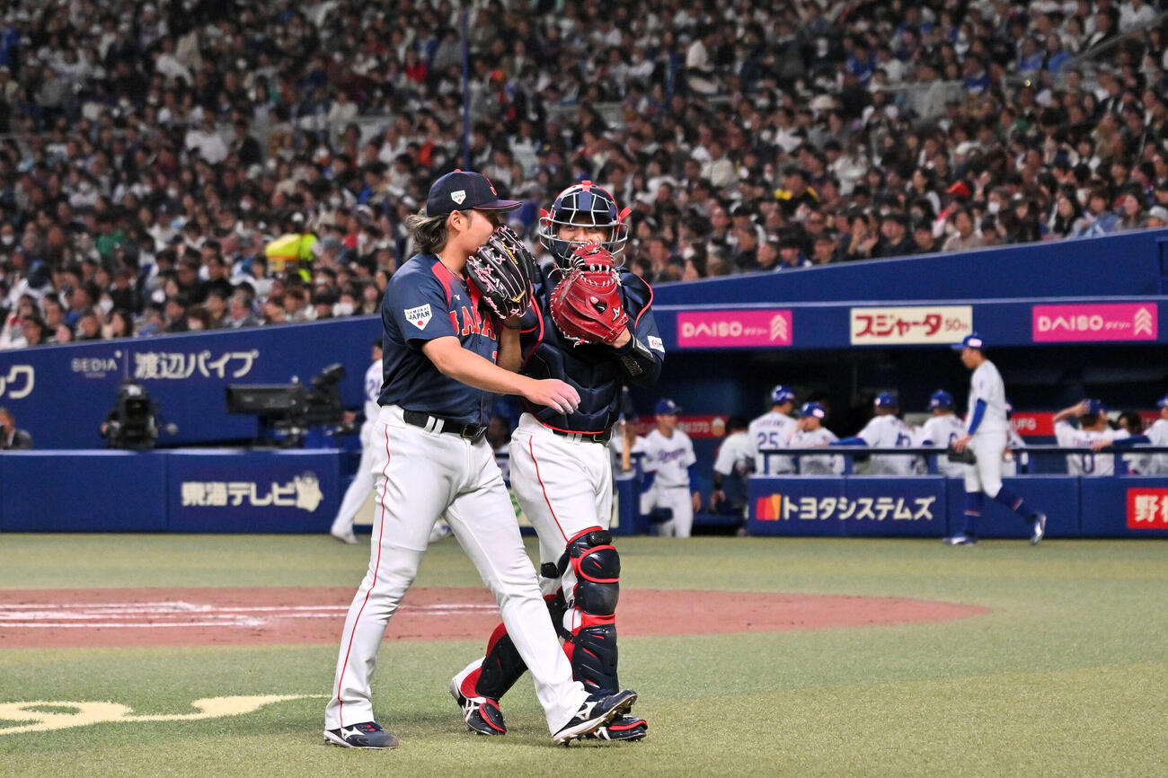 中日対日本　1回を投げ終えた日本先発の伊藤（左）は坂本と引き揚げる（撮影・滝沢徹郎）