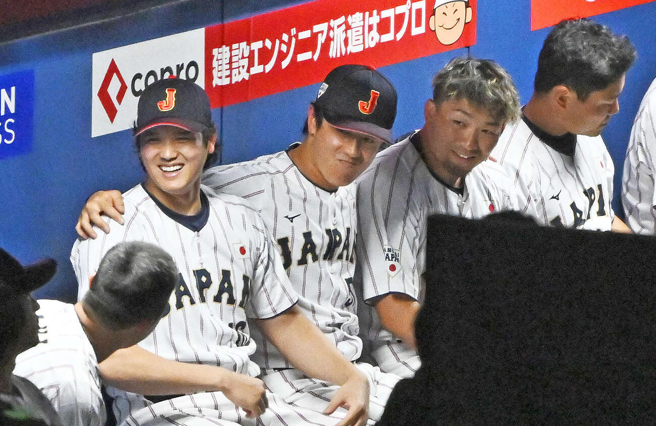 日本対中日　試合前にベンチで大谷（左から2人目）と鈴木（同4人目）の肩に腕を回させられて困る北山（中央）（26年2月27日撮影）