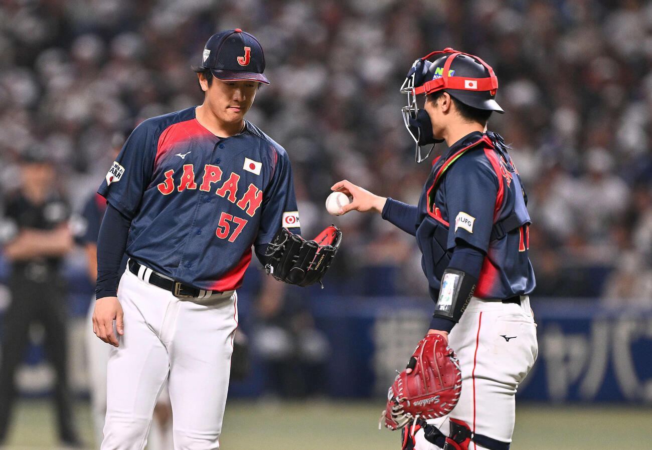 中日対日本　6回裏、マウンドの北山（左）にボールを渡す坂本（撮影・滝沢徹郎）