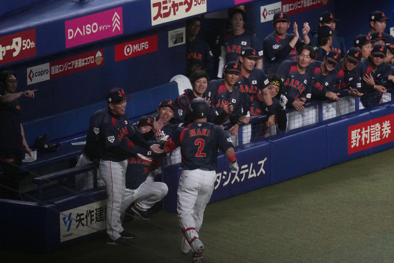 中日対日本　1回表日本2死、左越え本塁打を放つ牧（手前）を出迎える井端監督（左端）らナイン（撮影・井上学）