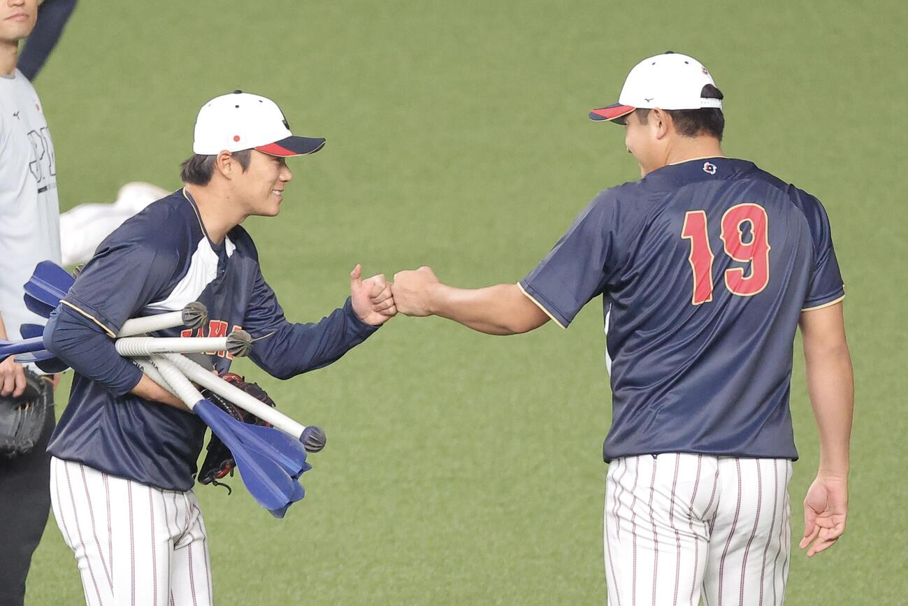 日本対オリックス　試合前、グータッチを交わす山本（左）と菅野（撮影・河田真司）