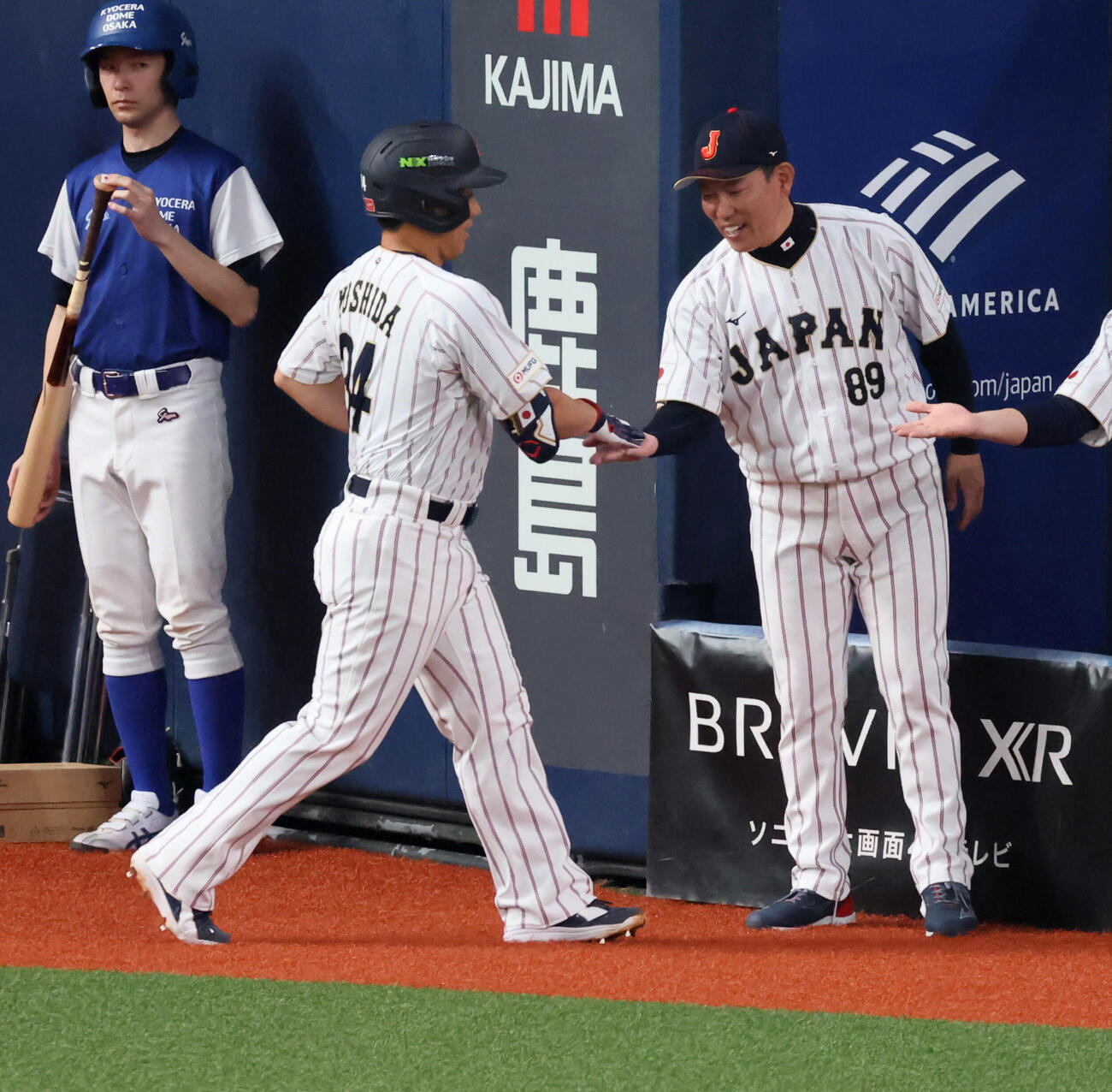 日本対オリックス　5回表日本1死、吉田は右越えソロ本塁打を放ちベンチの井端監督（右）とタッチする（撮影・加藤哉）