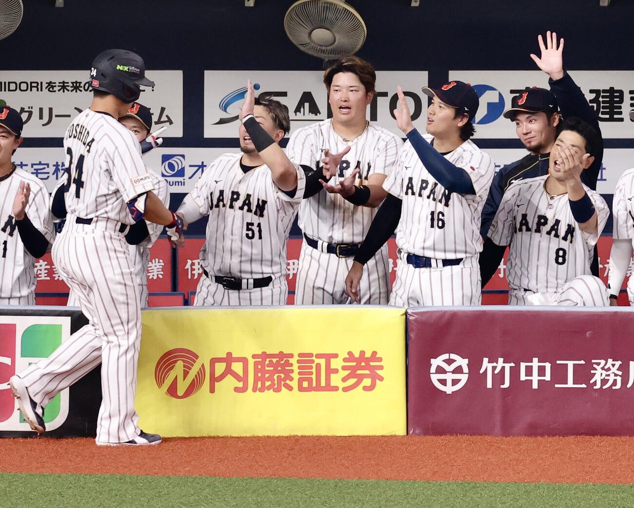 日本対オリックス　5回表日本1死、右越えソロ本塁打で生還する吉田（手前）を迎える大谷（右から3人目）らチームメート（撮影・河田真司）
