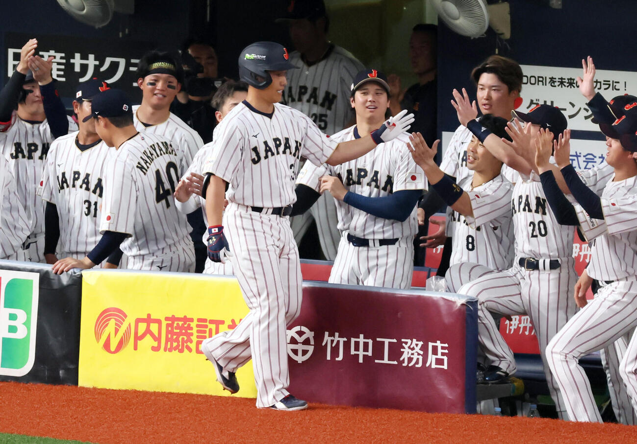 日本対オリックス　5回表日本1死、吉田は右越えソロ本塁打を放ちベンチの大谷らナインとタッチする（撮影・加藤哉）