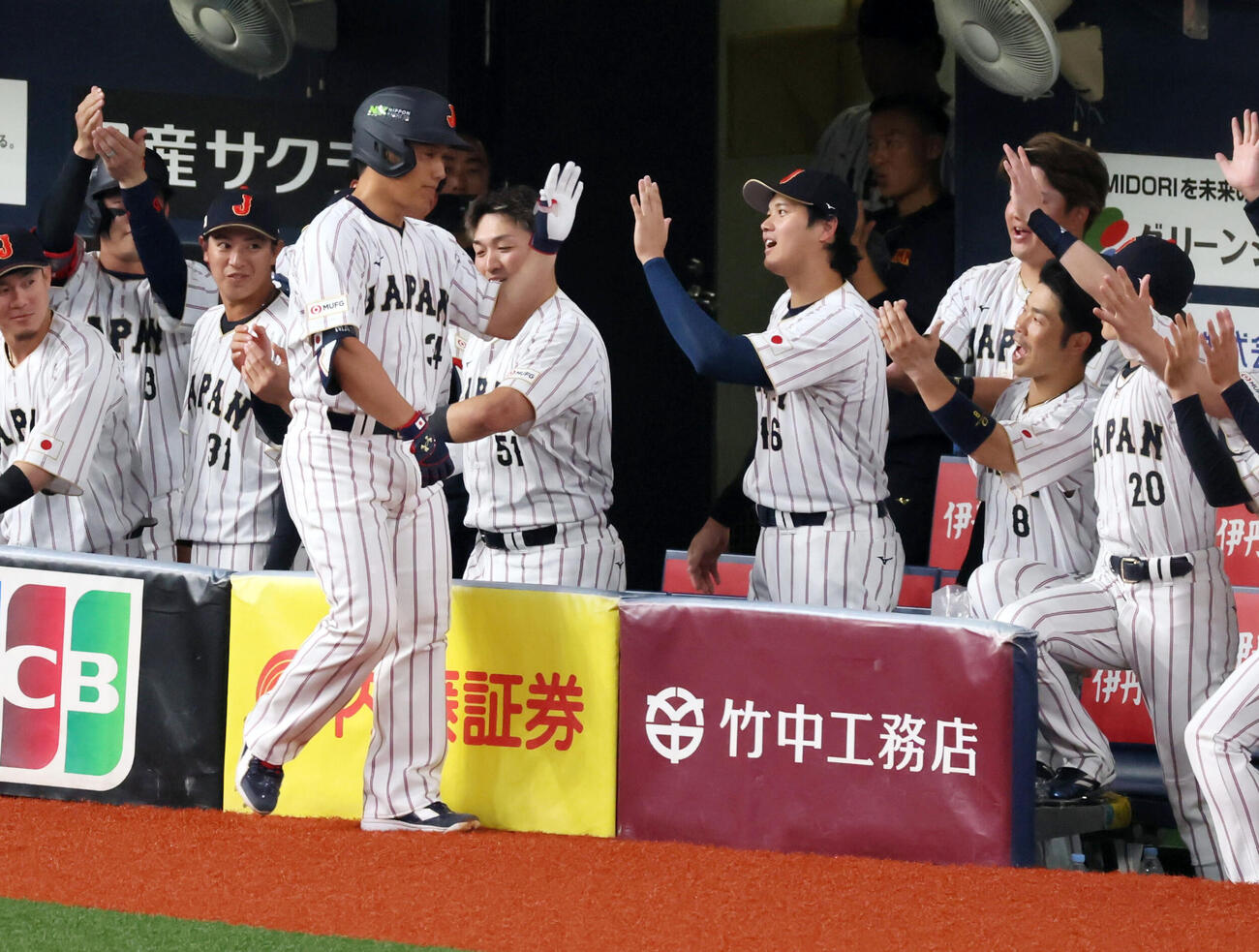日本対オリックス　5回表日本1死、吉田は右越えソロ本塁打を放ちベンチの大谷らナインとタッチする（撮影・加藤哉）