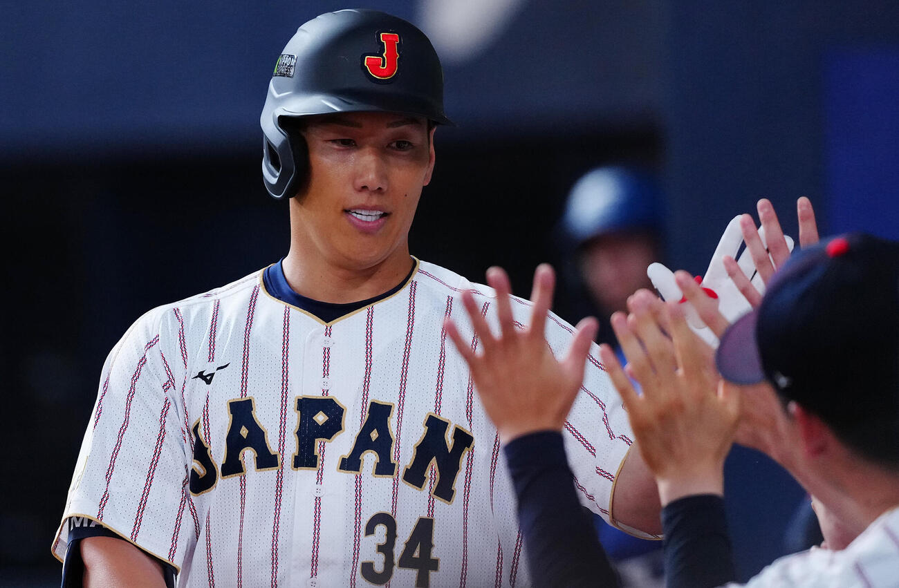 日本対オリックス　5回表日本1死、右越えソロ本塁打を放ちナインの出迎えを受ける吉田（撮影・垰建太）