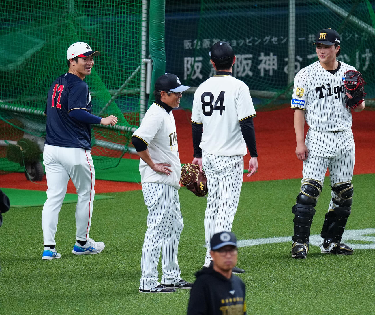 阪神対日本　試合前、阪神伏見（右）らコーチ陣にあいさつする坂本（左）（撮影・垰建太）