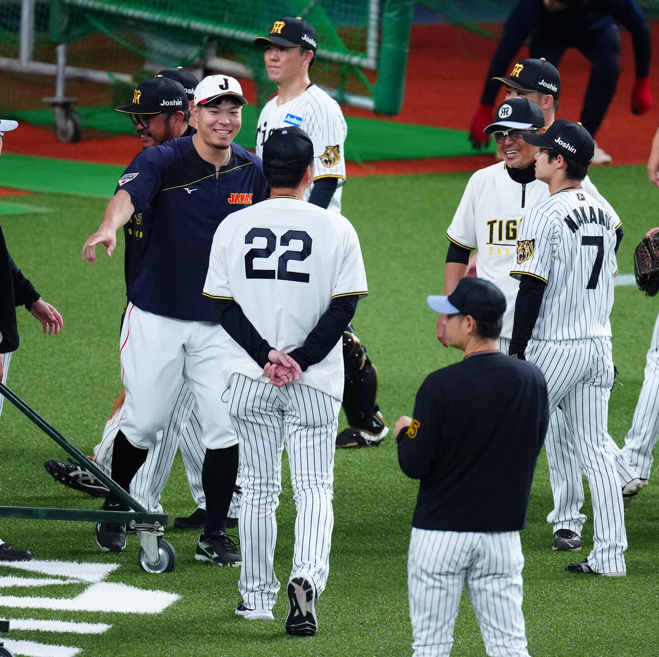 阪神対日本　試合前、阪神藤川監督（22番）らにあいさつする佐藤（左）（撮影・垰建太）