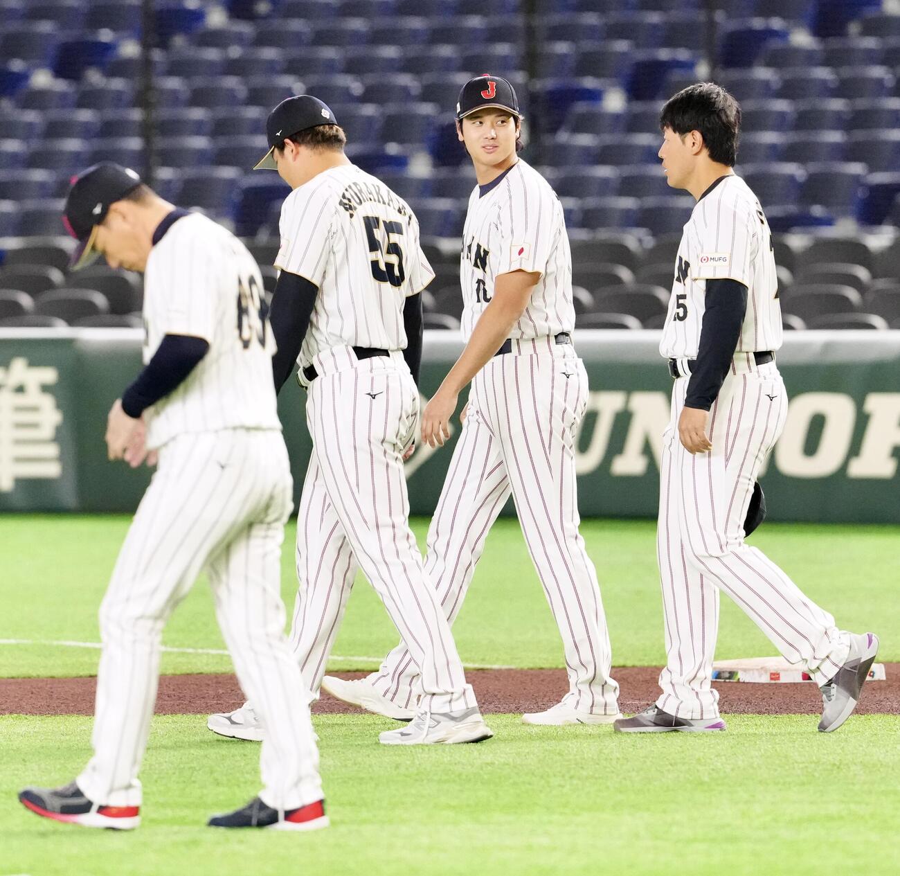 WBC公式練習前、集合写真撮影に向かう大谷（左から3人目）。左から井端監督、村上、1人おいて岡本（撮影・江口和貴）
