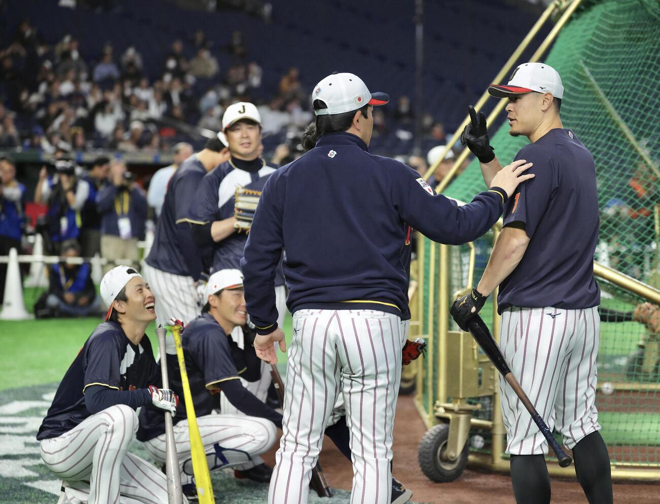 打撃練習で周東（左）らと言葉を交わす佐藤輝（右）（撮影・河田真司）