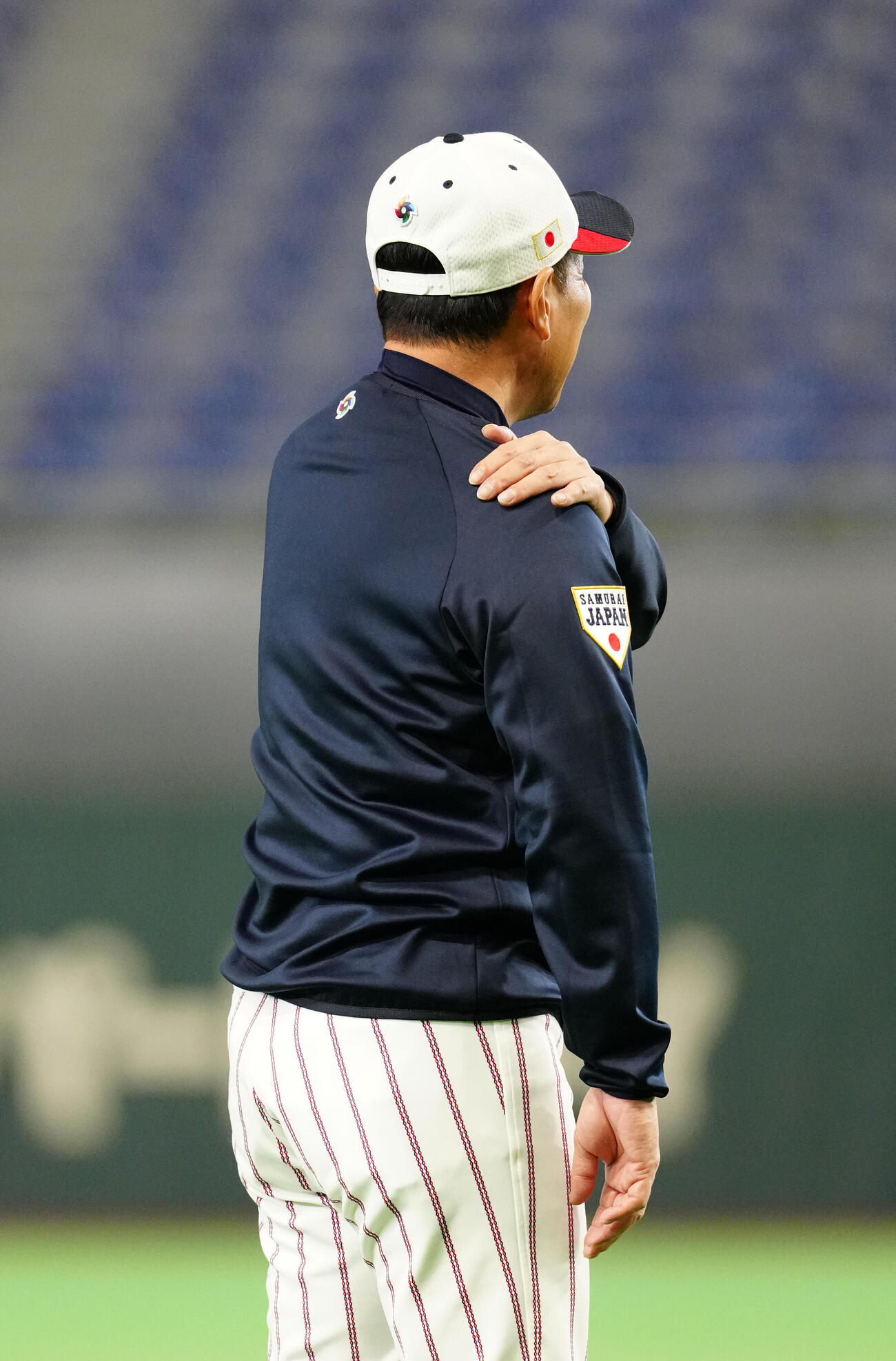 マウンド付近からの投球後、肩を触る井端監督（撮影・江口和貴）