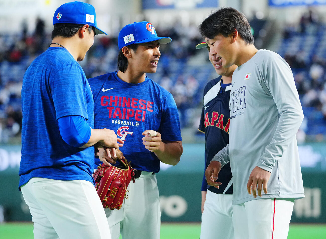台湾対日本　試合前、日本の源田（右）らに負傷した指を見せる台湾の陳傑憲（中央）（撮影・垰建太）