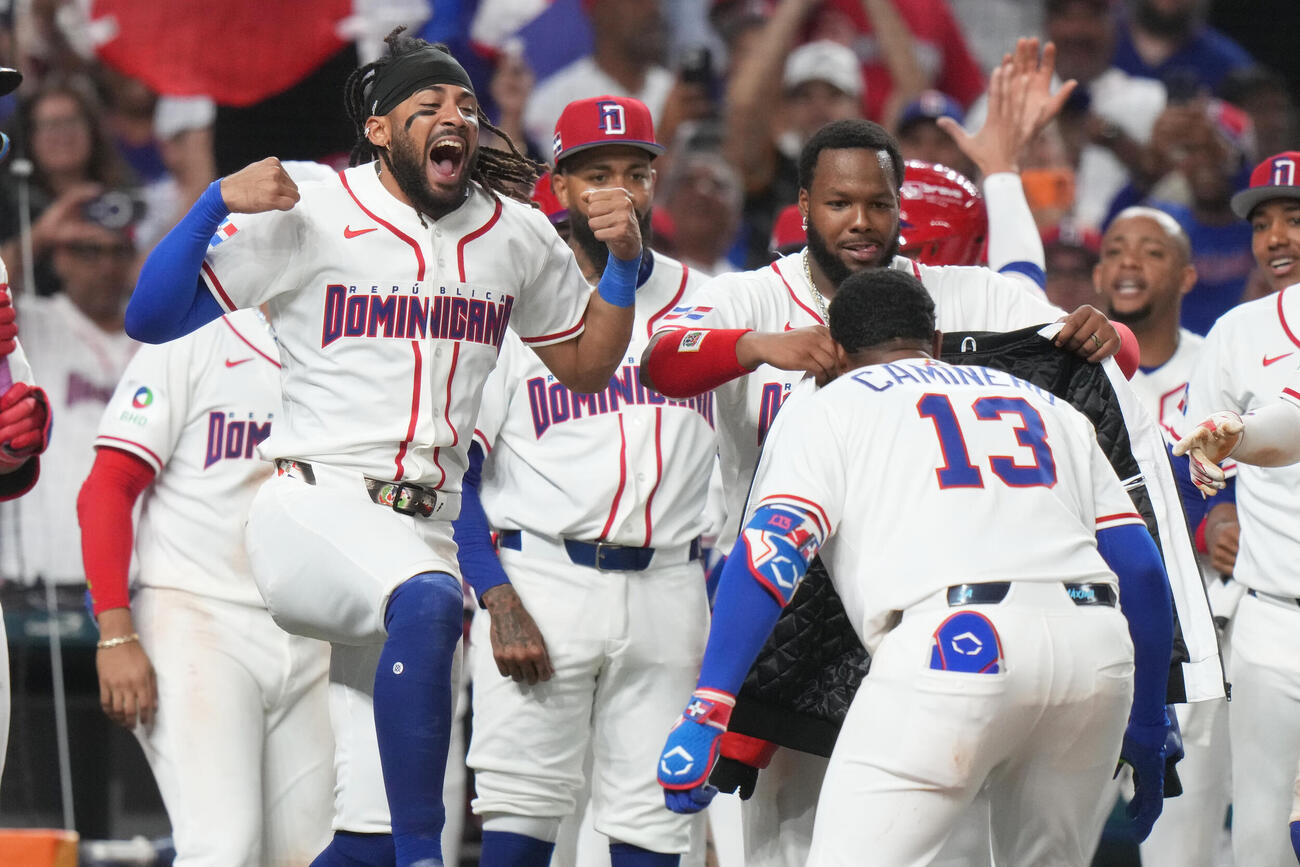 6回、勝ち越し2ランを放ったドミニカ共和国・カミネロを迎えるチームメイト（AP）