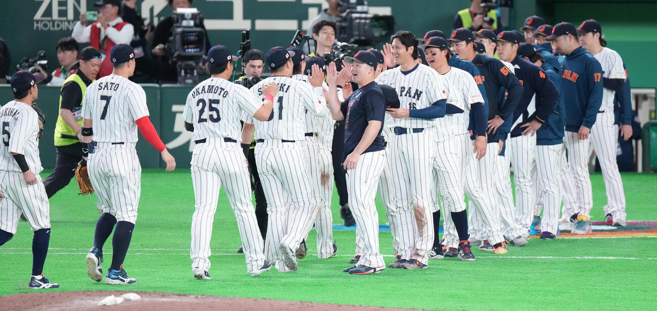 日本対韓国　韓国に勝利し、ナインを笑顔で迎える大谷（中央右）と牧（撮影・鈴木みどり）
