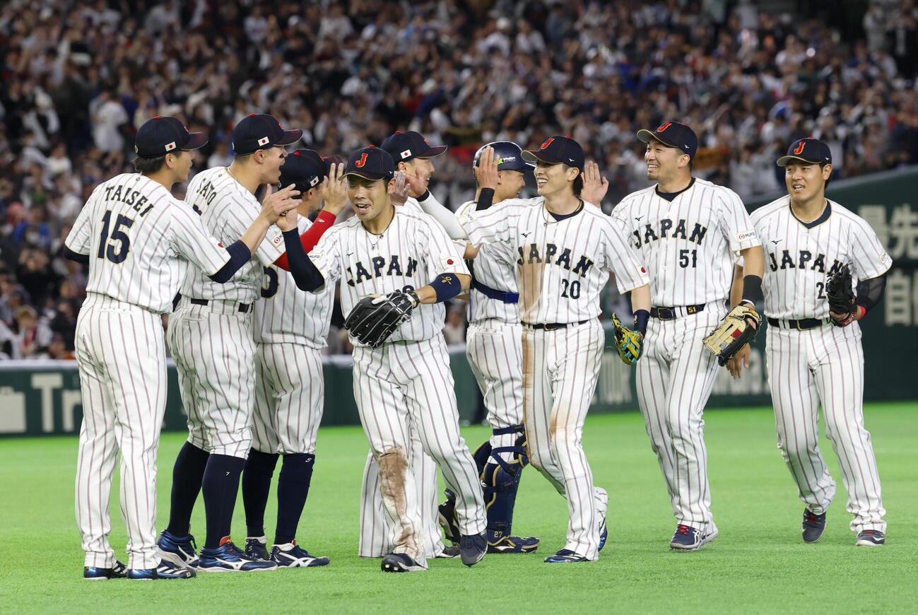 韓国に勝利し、タッチを交わす日本の（右から）岡本、鈴木、周東ら（共同）