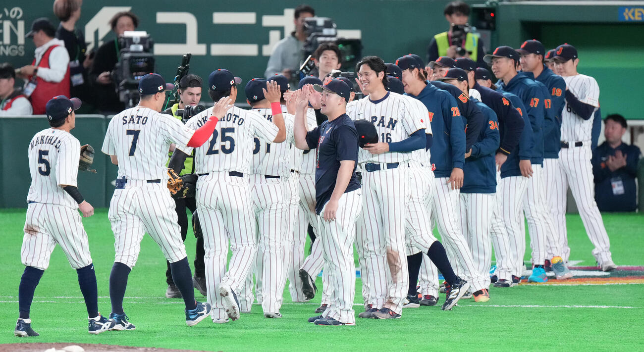 日本対韓国　韓国に勝利し、ナインを笑顔で迎える大谷（中央）と牧（撮影・鈴木みどり）