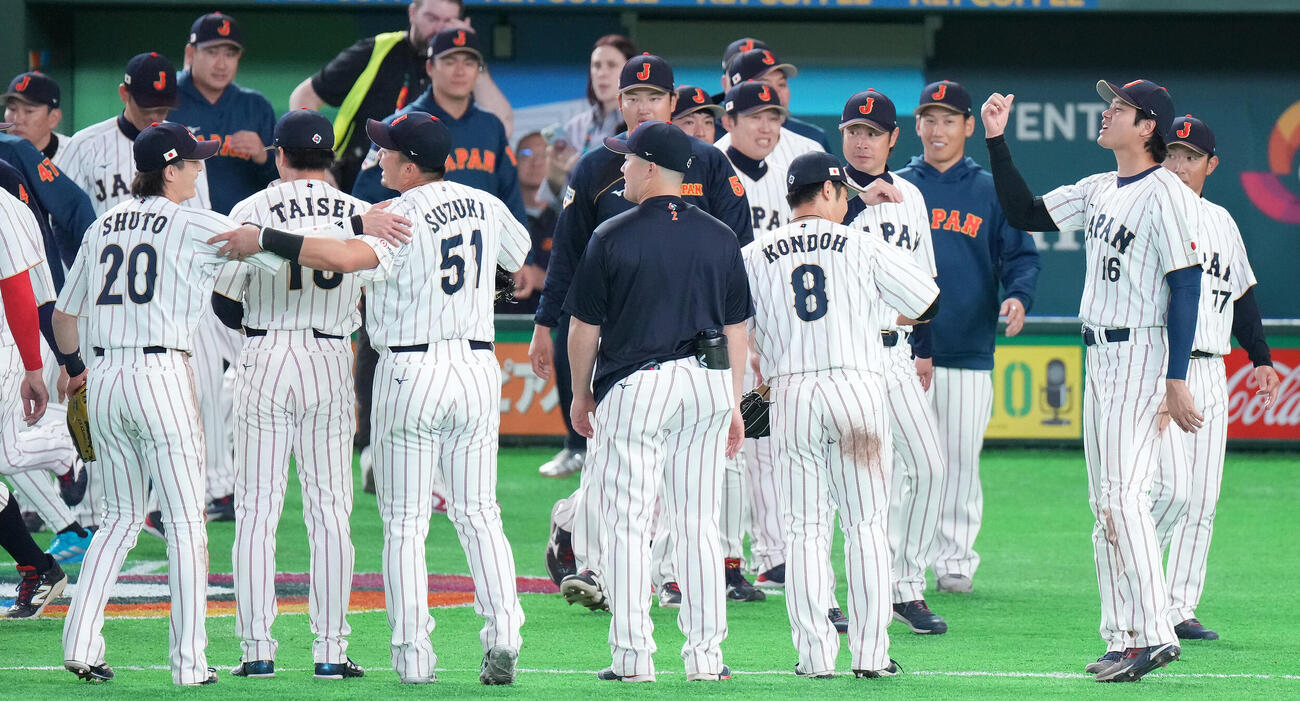 日本対韓国　韓国に勝利し、ファンに一礼する際に前に出るのを譲り合う周東（左）と鈴木（左から3人目）。右は大谷（撮影・鈴木みどり）
