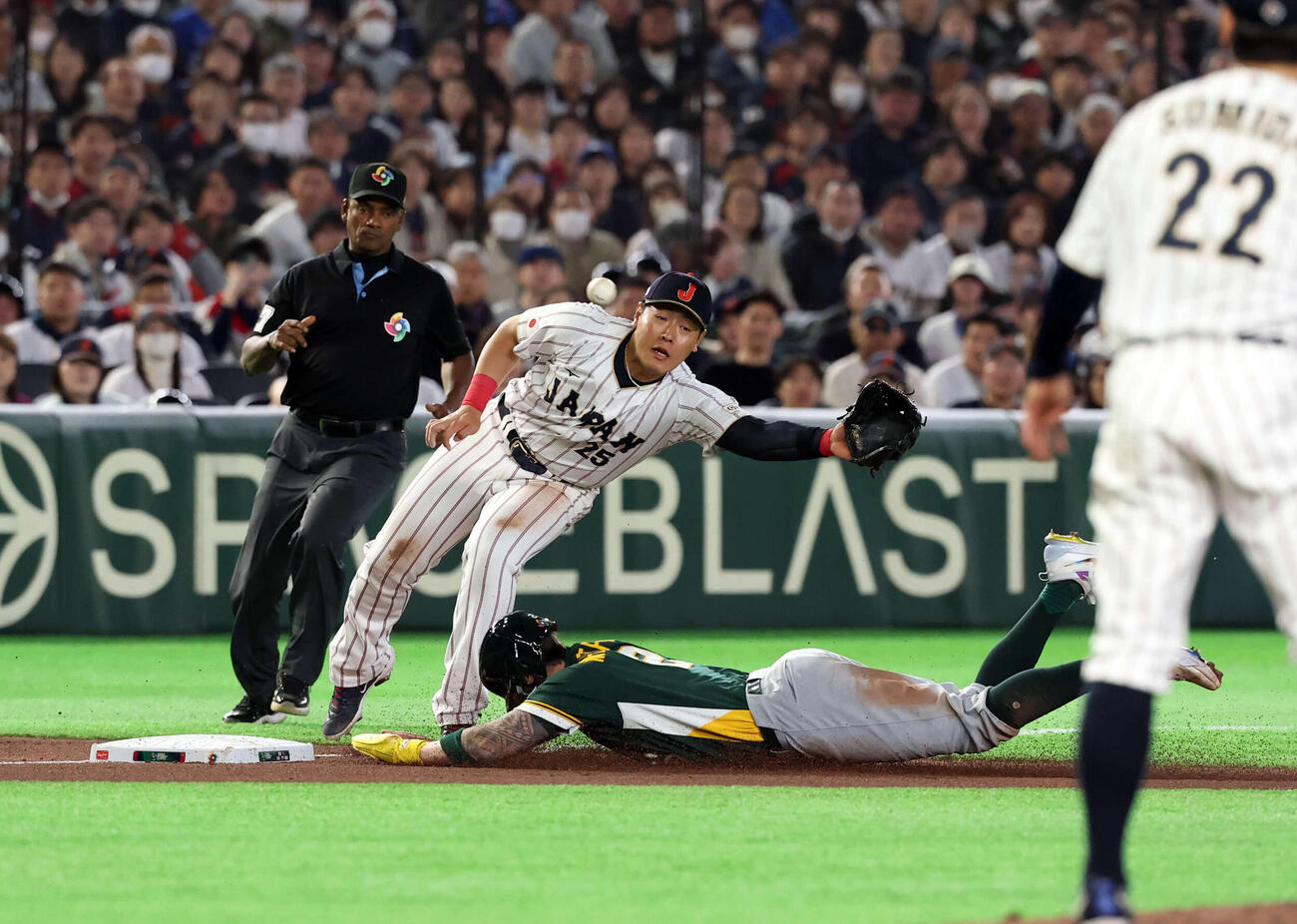 日本対オーストラリア　6回表オーストラリア1死二塁、二塁走者ホワイトヂールド（下）の三塁盗塁で、捕手若月の悪送球を岡本は捕れず先制点を許す（撮影・浅見桂子）