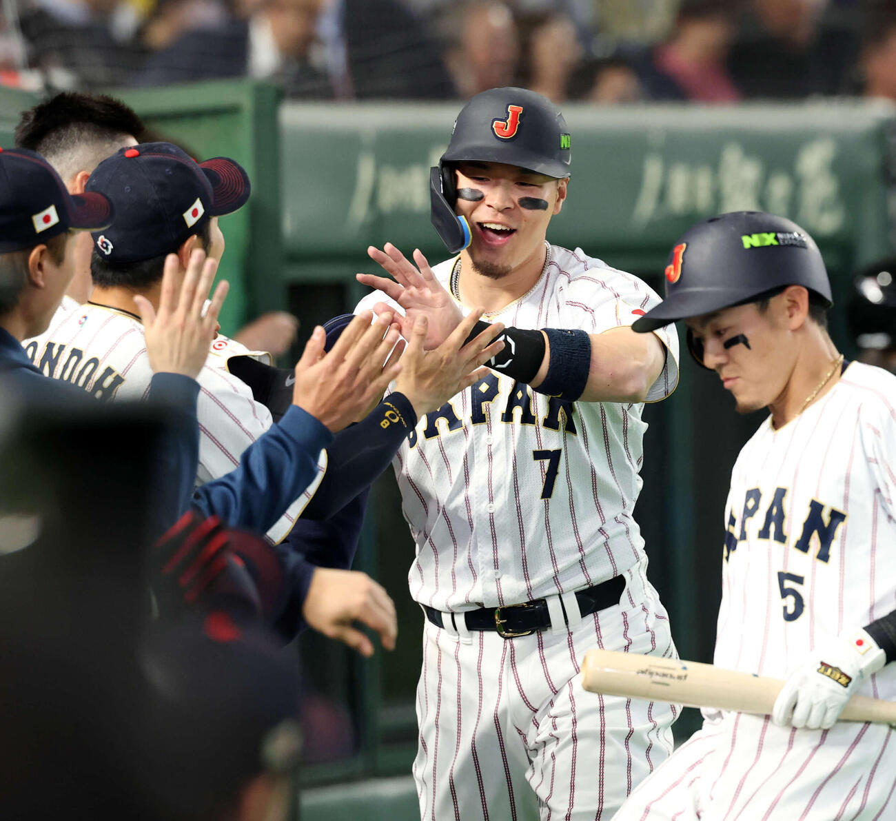日本対オーストラリア　8回裏日本の攻撃で左適時二塁打を放った佐藤はベンチでナインとハイタッチ（撮影・浅見桂子）