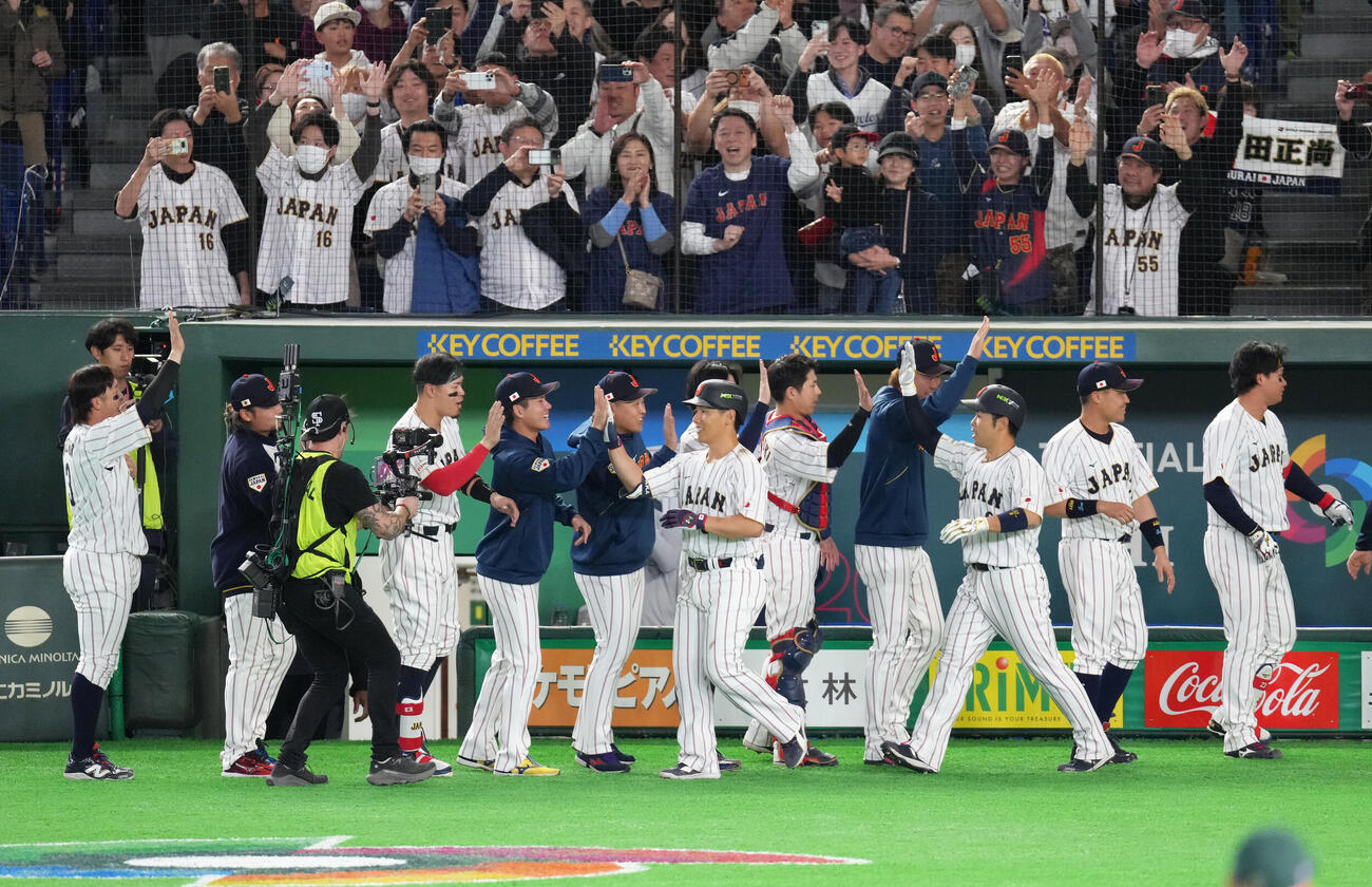 日本対オーストラリア　7回裏日本2死一塁、吉田（中央）は逆転の2点本塁打を放ちタッチを交わす（撮影・足立雅史）