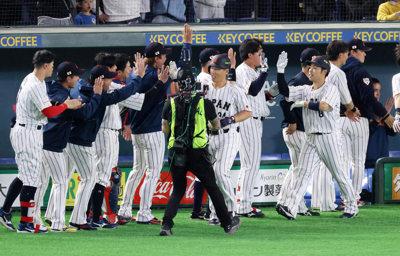 日本対オーストラリア　7回裏日本2死一塁、吉田は逆転右中間越え2点本塁打を放ちベンチのナインと笑顔でタッチ。右は一走近藤（撮影・加藤哉）