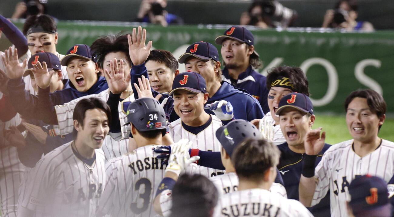 7回、逆転2ランを放った吉田（手前左から2人目）を笑顔で迎える日本代表（共同）